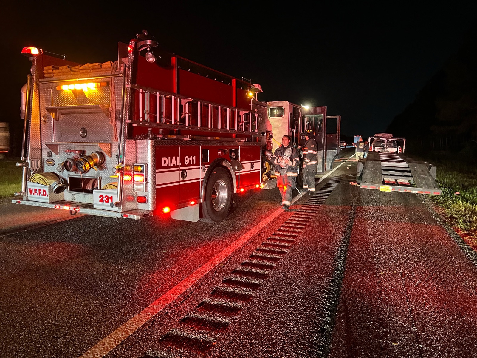 Crew dismounting Engine 231 on a roadway during a nighttime response