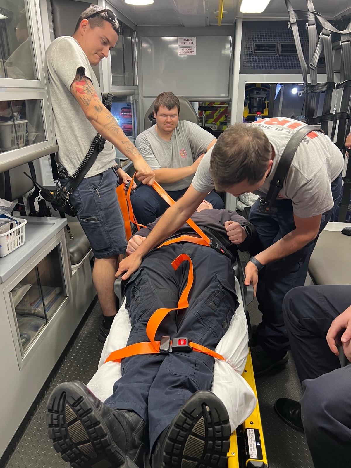 Crew practicing a patient lift inside the back of a rescue unit